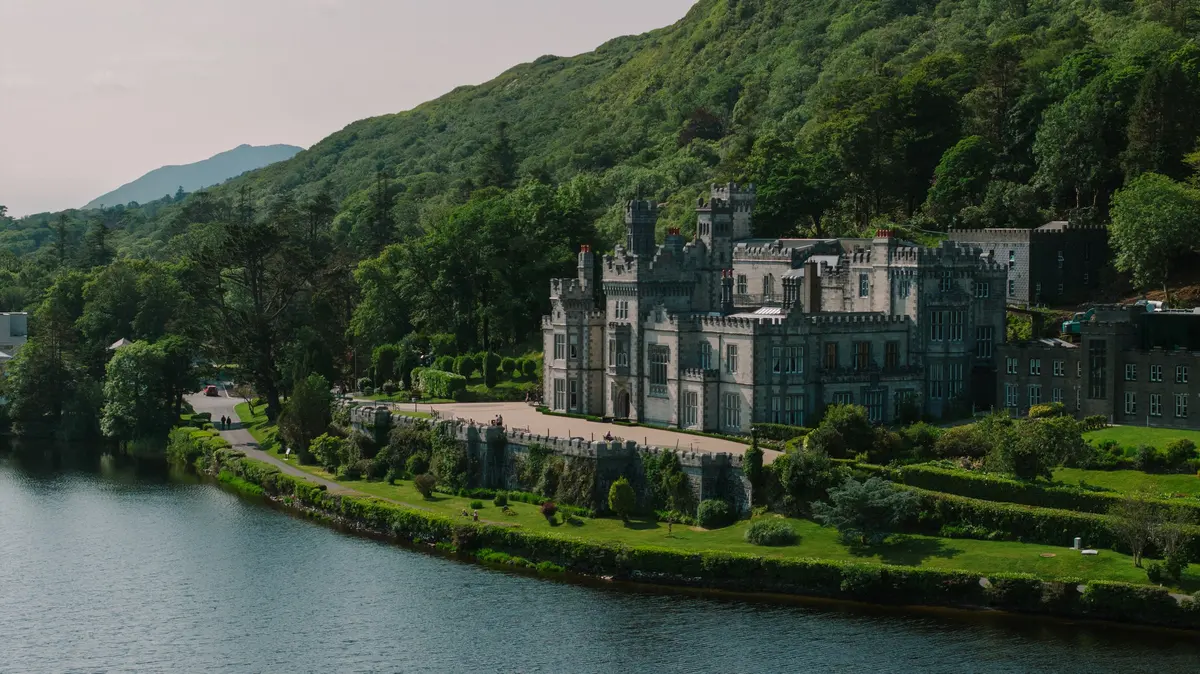 Kylemore Abbey beside its lake and wooded Connemara hillside